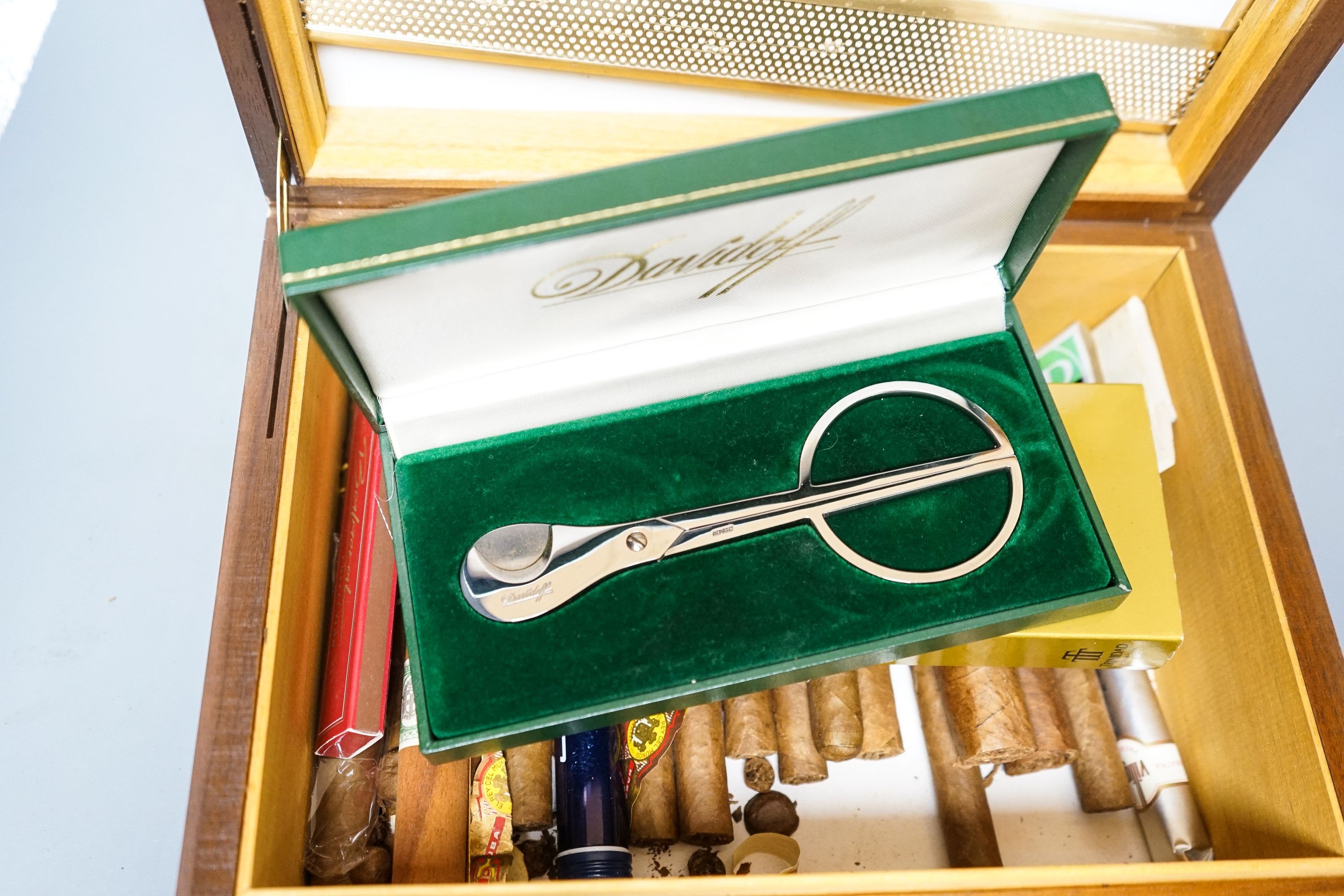 A cased Davidoff cigar cutter, walnut humidor, plated cigarette box, various cigars etc.